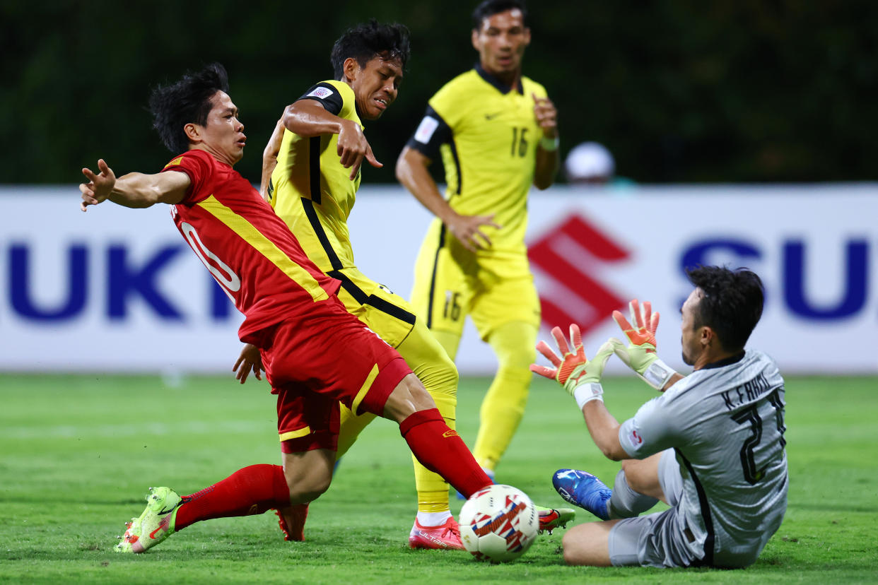 Vietnam striker Nguyen Cong Phuong (red jersey) attempts to score against Malaysia goalkeeper Khairul Fahmi during their AFF Suzuki Cup match.