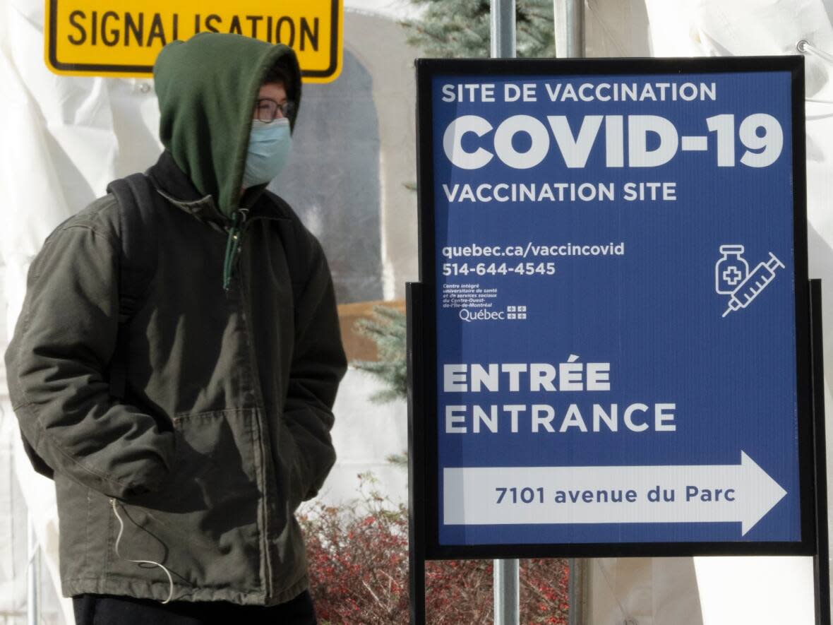 A man enters a COVID-19 vaccination site Wednesday in Montreal. The National Advisory Committee on Immunization (NACI) is now strongly recommending Canadians over the age of 50 and other vulnerable groups get a third dose of an mRNA COVID-19 vaccine. (Ryan Remiorz/The Canadian Press - image credit)