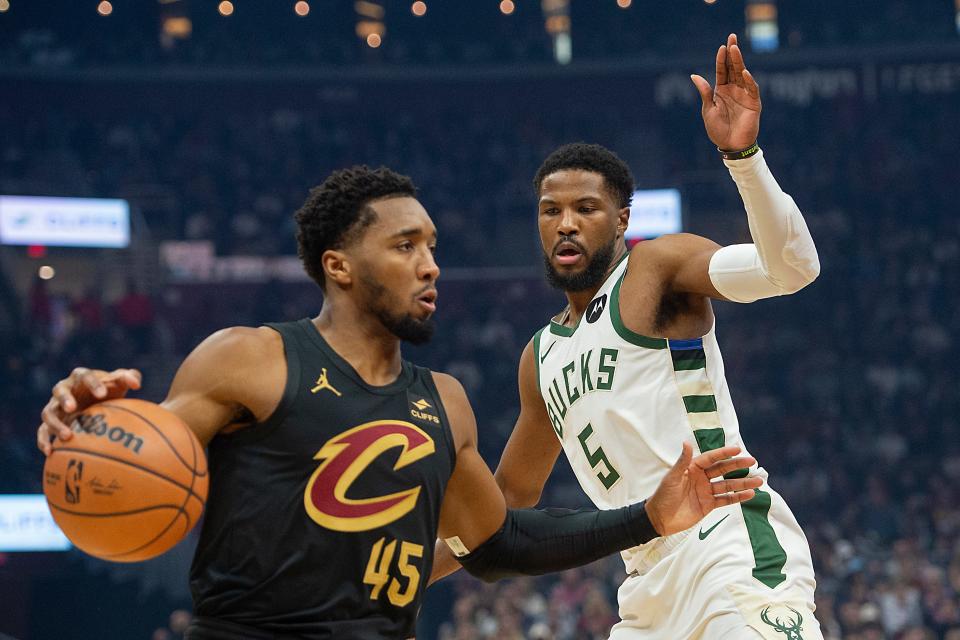 Cleveland Cavaliers' Donovan Mitchell (45) drives past Milwaukee Bucks' Malik Beasley (5) during the first half of an NBA basketball game in Cleveland, Friday, Dec. 29, 2023. (AP Photo/Phil Long)