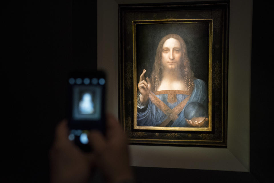 NEW YORK, NY - NOVEMBER 15: A visitor takes a photo of the painting 'Salvator Mundi' by Leonardo da Vinci at Christie's New York Auction House, November 15, 2017 in New York City. The coveted painting is set to be auctioned off on Wednesday night and has been guaranteed to sell for over $100 million.(Drew Angerer/Getty Images)