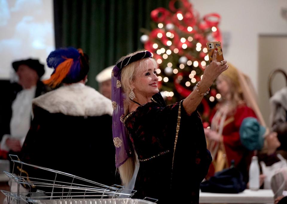 Cynthia Tsonas takes a photo of herself dressed as a lady of the manor during the 2024 Boar's Head and Yule Log Festival on Saturday.