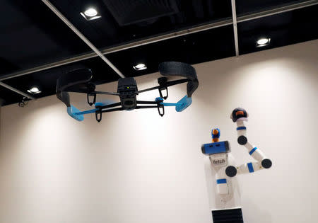 A drone takes photos of a robot during a demonstration of Xpose, an interactive drone photo-taking system, at the NUS School of Computing faculty premises in Singapore November 27, 2017. REUTERS/Edgar Su/Files