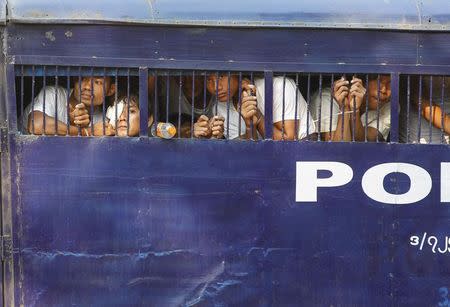 Student protesters are seen in a prison vehicle as they transported to a court in Letpadan March 11, 2015. REUTERS/Soe Zeya Tun