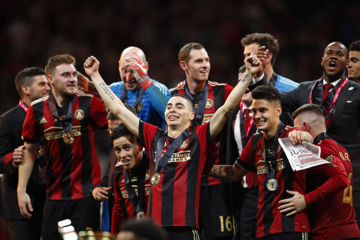 Atlanta United midfielder Miguel Almiron (10) celebrates with his teammates as they take the stage for the trophy presentation after the MLS Cup championship soccer game against the Portland Timbers, Saturday, Dec. 8, 2018, in Atlanta. Atlanta United won 2-0. (AP Photo/Todd Kirkland)