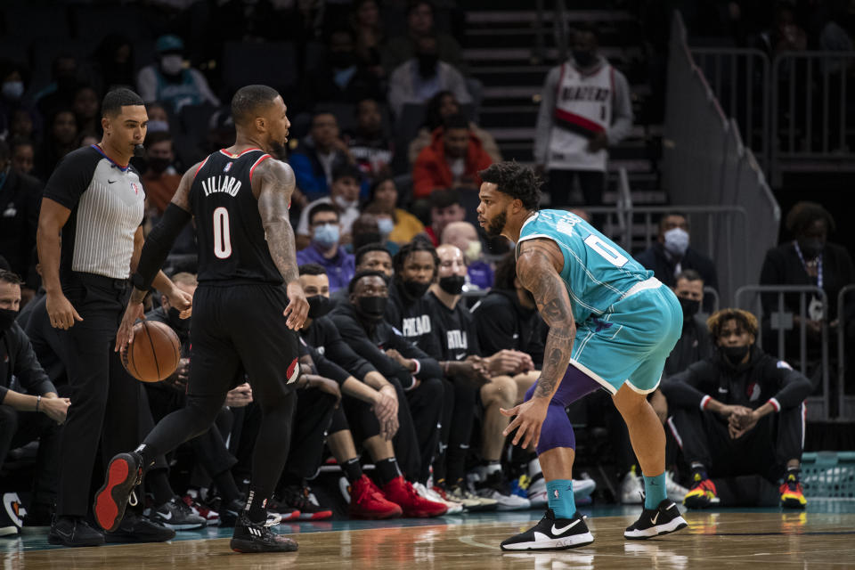 Charlotte Hornets forward Miles Bridges (0) defends Portland Trail Blazers guard Damian Lillard (0) during the first half of an NBA basketball game, Sunday, Oct. 31, 2021, in Charlotte, N.C. (AP Photo/Matt Kelley)