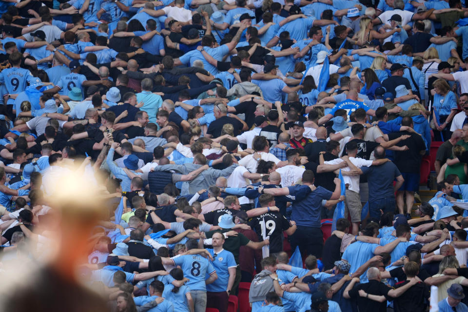 Manchester City fans stand with their backs to the pitch ahead of the English FA Cup final soccer match between Manchester City and Manchester United at Wembley Stadium in London, Saturday, June 3, 2023.(AP Photo/Jon Super)