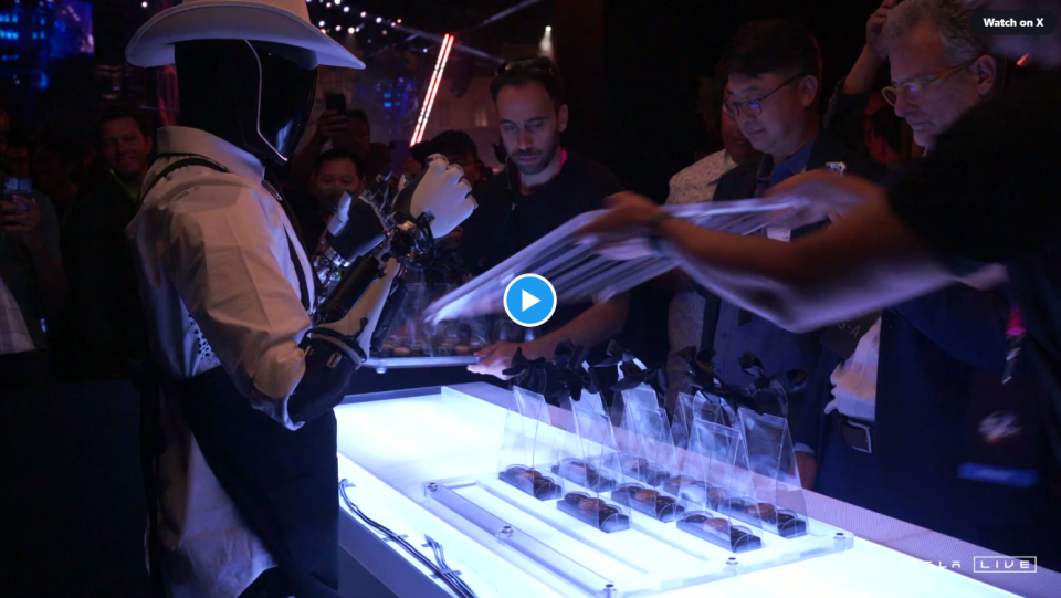 The Tesla Bot serves the bar at a conference.