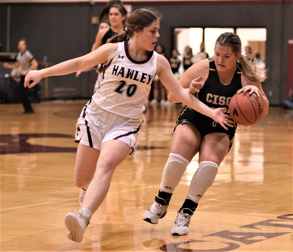 Hawley's Sawyer Gilman (20) defends as Cisco's Justice Fox brings the ball up court.