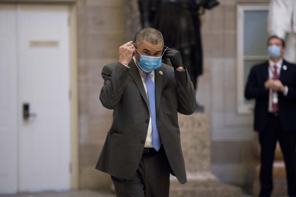 FILE - In this April 23, 2020, file photo, Rep. William Lacy Clay, D-Mo., puts on his mask as he walks towards the House Chamber on Capitol Hill, in Washington. National lawmakers are expected on Wednesday to introduce a joint resolution aimed at striking language from the U.S. Constitution that enshrines a form of slavery in America’s foundational documents. A House version is led by outgoing Clay, who said the amendment “seeks to finish the job that President (Abraham) Lincoln started.” (AP Photo/Andrew Harnik, File)