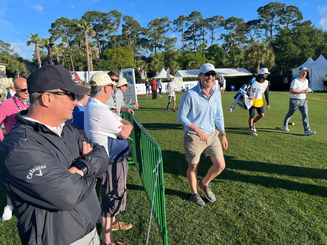 Michael Wertheim of Charlottesville, Virginia was all smiles after hitting a good drive on the first hole at the RBC Heritage Pro-Am featuring pros and amateurs. Professional player Luke Donald walks behind him.