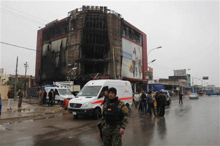 Iraqi security forces personnel inspect the site following an attack by gunmen and suicide bombers on a police intelligence headquarters and a shopping mall in Kirkuk, 250 km (155 miles) north of Baghdad, December 5, 2013. REUTERS/Ako Rasheed