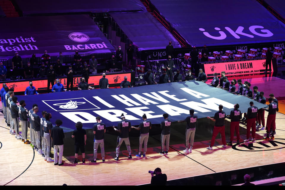 Miami Heat and Detroit Pistons players hold a "I Have a Dream" banner in honor of the Martin Luther King Jr., holiday before an NBA basketball game, Monday, Jan. 18, 2021, in Miami. (AP Photo/Marta Lavandier)