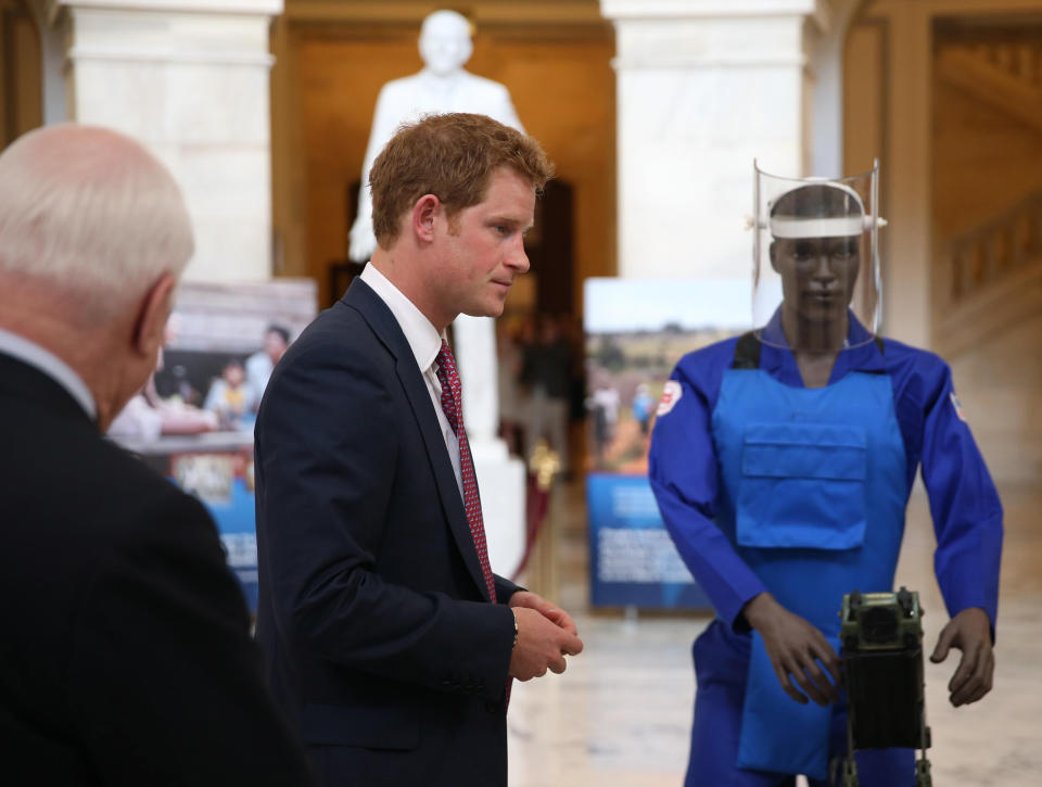 Senator John McCain and Prince Harry tour an anti-landmine photography exhibition by The HALO Trust charity. The charity was well supported by his mother and he became patron of the charity earlier this year (PA)