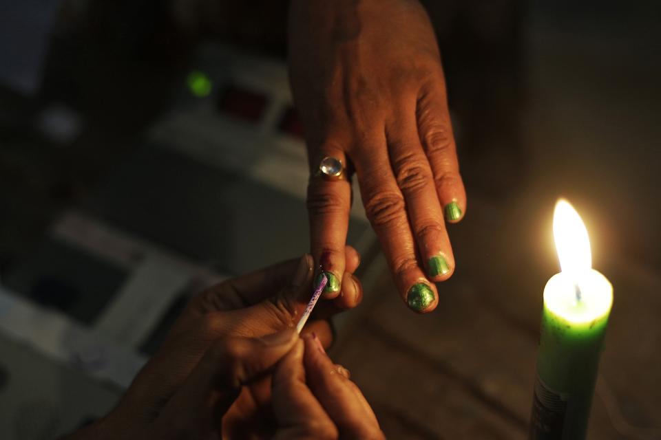 A polling official ink marks the index finger of a woman voter during the sixth phase of polling of the Indian parliamentary elections in Gauhati, India, Thursday, April 24, 2014.The multiphase voting across the country runs until May 12, with results for the 543-seat lower house of parliament expected on May 16. (AP Photo/Anupam Nath)