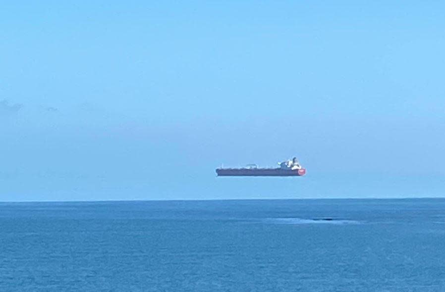 A ship appears to hover over the sea off the coast of Cornwall, England. / Credit: David Morris/APEX