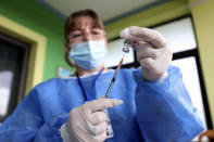 Nurse Anila Shameti prepares a syringe before jabbing a resident in Sukth village, about 33 kilometers (20 miles) west of Tirana, Albania, Tuesday, Nov. 16, 2021. The emergence of the new omicron variant and the world’s desperate and likely futile attempts to keep it at bay are reminders of what scientists have warned for months: The coronavirus will thrive as long as vast parts of the world lack vaccines. (AP Photo/Franc Zhurda)