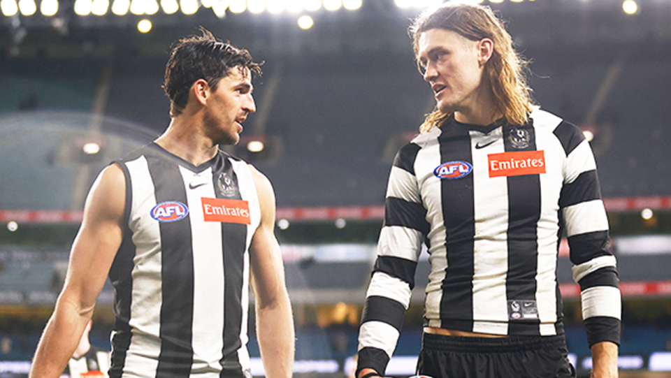 Darcy Moore (pictured right) walking off the field with captain Scott Pendlebury (pictured left).