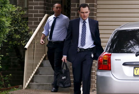 Federal police officers exit a house after arresting a man during early morning raids in western Sydney, Australia, October 7, 2015. REUTERS/David Gray