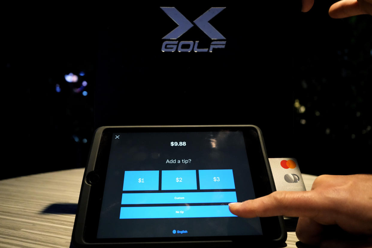 A tipping option is displayed on a card reader tablet at X-Golf indoor golf in Glenview, Ill., Tuesday, Jan. 10, 2023. Tipping fatigue, it seems, is swarming America as more businesses adopt digital payment methods that automatically prompts customers to leave a gratuity. (AP Photo/Nam Y. Huh)