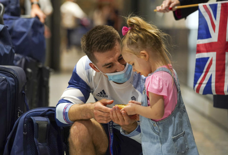 Olympic gymnast Max Whitlock with his daughter Willow as he arrives back at London Heathrow Airport from the Tokyo 2020 Olympic Games. Picture date: Tuesday August 3, 2021.