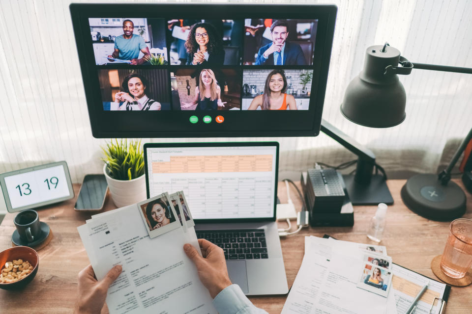 A person holding resumes at their desk