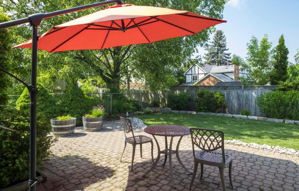 Cantilever umbrella providing shade by a table and chairs