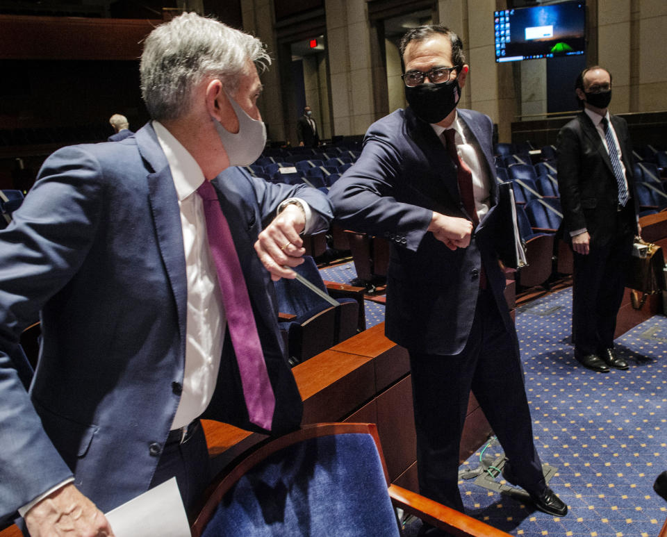 Federal Reserve Board Chairman Jerome Powell, left, and Treasury Secretary Stephen Mnuchin, bump elbows at the conclusion of a House Committee on Financial Services hearing on oversight of the Treasury Department and Federal Reserve pandemic response, Tuesday, June 30, 2020 on Capitol Hill in Washington. (Bill O'Leary/The Washington Post via AP, Pool)