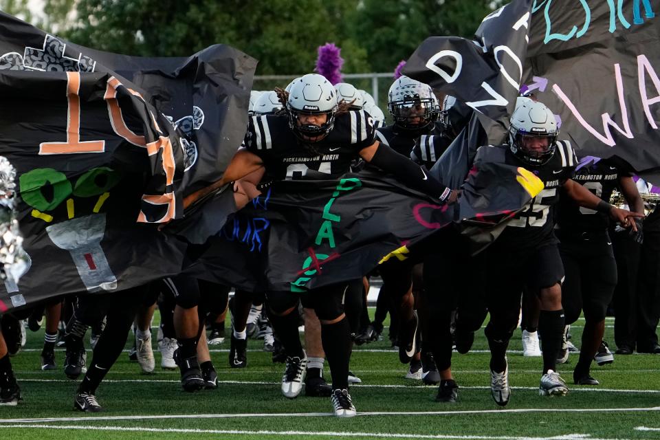 Defensive lineman Angelo McCullom leads Pickerington North onto the field Friday night. The Panthers beat visiting Pickerington Central 39-34 to improve to 4-0.