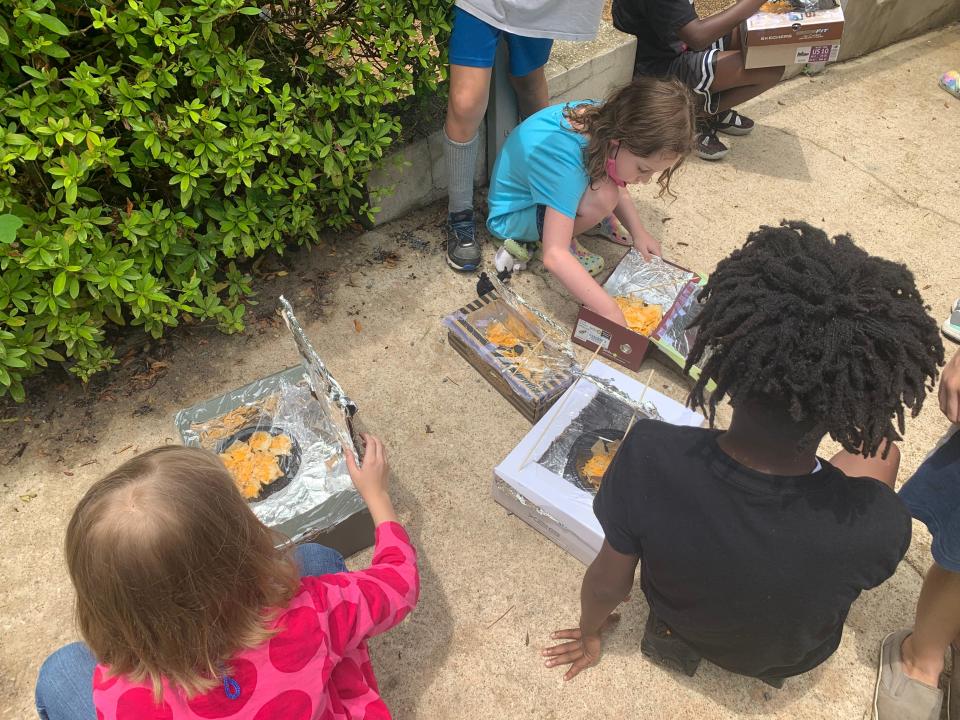 Rethink Energy campers cooking with their shoebox solar ovens.