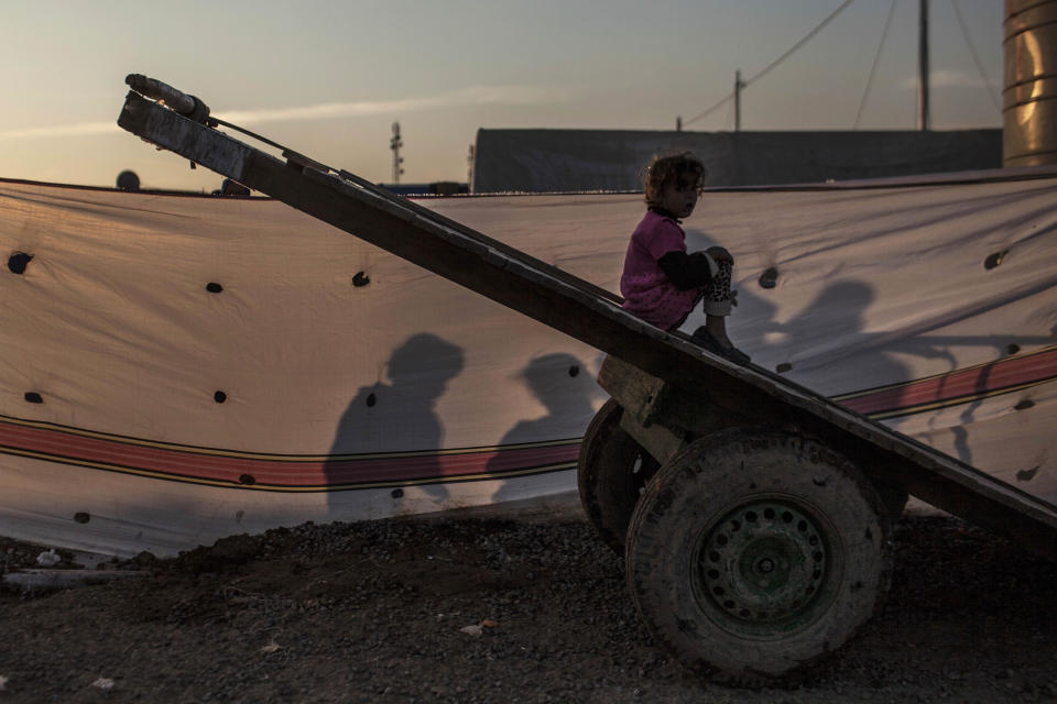 An Iraqi girl plays atop of a carriage in Khazer camp for the displaced in Iraqi Kurdistan, Iraq, Monday, Dec. 12, 2016. A new report criticizes the U.S.-led coalition against IS for their lack of transparency when assessing civilian casualties. (AP Photo/Manu Brabo)