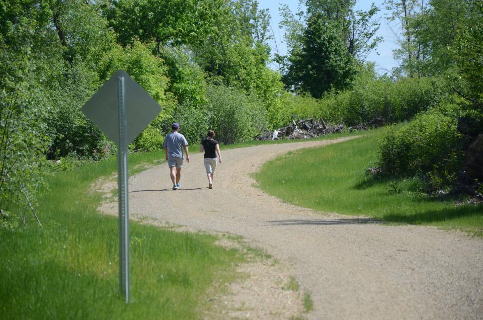 In this 2015 photo, Kim Schrier of Richland and David Meadows of Battle Creek walk the trail in Kimball Pines Park in Emmett Township.