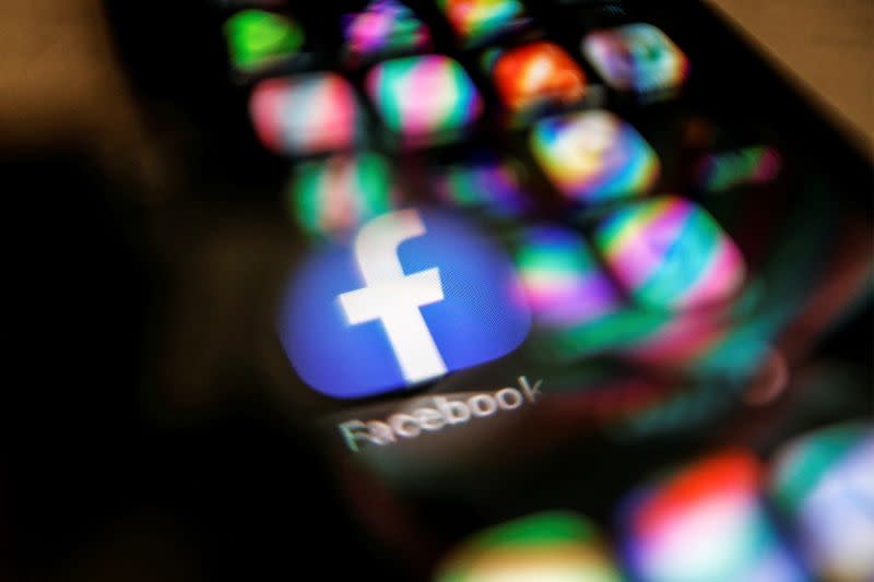 FILE PHOTO: Facebook logo displayed on a mobile phone is seen through a magnifying glass in this picture illustration