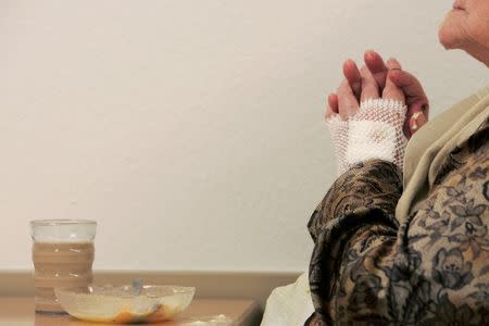 A pensioner takes a break during lunch at a residential home for the elderly in Emmenbruecke near Lucerne in this December 7, 2007 file photo. REUTERS/Christian Hartmann/Files