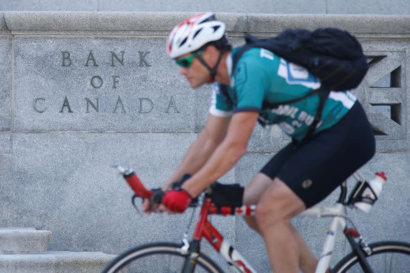 A cyclist rides past the Bank of Canada building