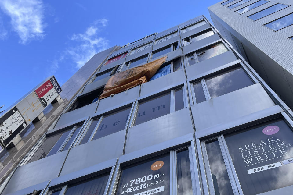 This photo shows a building where a fire broke out Friday in Osaka, western Japan, Saturday, Dec. 18, 2021. Japanese police on Saturday searched the house of one of the patients at a mental clinic where the fire gutted an entire floor in the eight-story building, killing over 20 people trapped inside. (AP Photo/Chisato Tanaka)