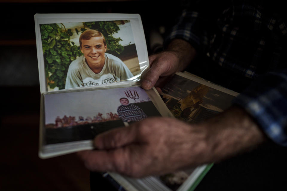 Oleksandr Turovskyi, whose 35-year old son Sviatoslav was among eight men executed in a vacant lot in the suburb of Bucha in March 2022, looks at pictures of his son at his apartment in Bucha, Ukraine, Saturday, March 30, 2024. Days after Russian forces withdrew from the area in late March, in the dramatic first weeks of the full-scale invasion, a photo taken by AP Photographer Vadim Ghirda revealed what happened to the eight men. (AP Photo/Vadim Ghirda)