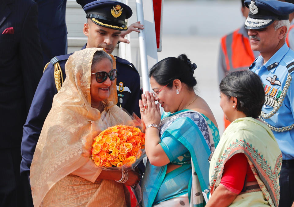 Bangladesh Prime Minister Sheikh Hasina, left is received with flowers as she arrives at the airport in New Delhi, India, Thursday, Oct.3, 2019. Hasina is on a three-day visit to India. (AP Photo/Manish Swarup)