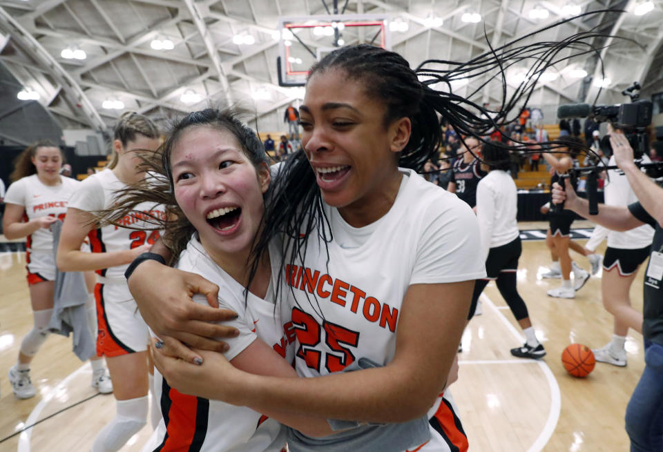 Princeton guards Kaitlyn Chen, left, and Chet Nweke (25) celebrate after defeating Harvard in the Ivy League tournament championship NCAA college basketball game, Saturday, March 11, 2023, in Princeton, N.J. Princeton won 54-48. (AP Photo/Noah K. Murray)