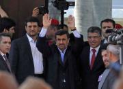Iranian President Mahmoud Ahmadinejad (C) waves alongside Venezuelan Minister of Foreign Affairs Elias Jaua (C-R) outside of the funeral of the late President Hugo Chavez, in Caracas, on March 8, 2013