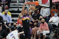 Phoenix Suns guard Devin Booker (1) dunks as he drives past Los Angeles Lakers forward Anthony Davis (3) during the first half of Game 1 of their NBA basketball first-round playoff series Sunday, May 23, 2021, in Phoenix. (AP Photo/Ross D. Franklin)