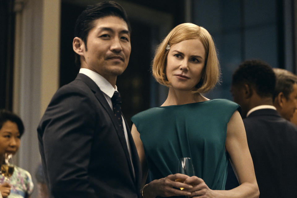 This image released by Prime Video shows Brian Tee, foreground, and Nicole Kidman in a scene from "The Expats." (Prime Video via AP)