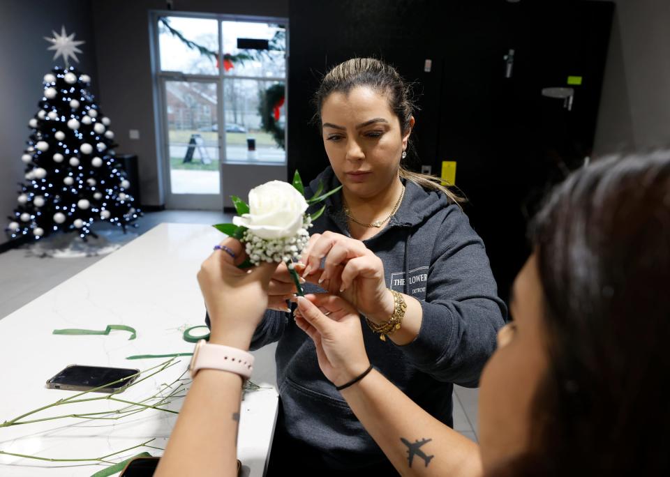 Nedaa Sobh, a co-owner of The Flower Shop Detroit in Dearborn Heights, works with florist Maria Gonzalez, 25, of Allen Park, on a flower for a client at their store on Dec. 9, 2022. The store is a florist and a coffee shop in one and opened in October 2022.