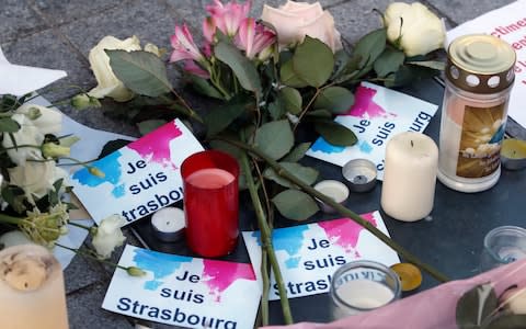 Flowers and candles are put with stickers reading "I am Strasbourg" in the streets for the victims following an attack killing three people and wounding at least 13 - Credit:  Christophe Ena/AP