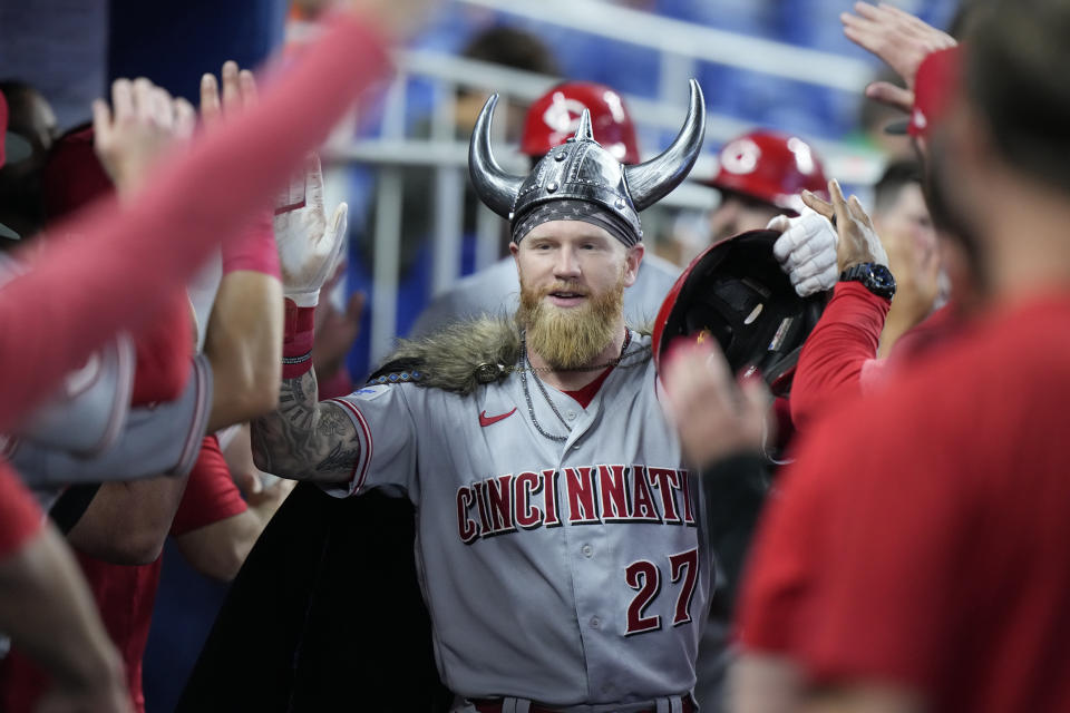 Cincinnati Reds' Jake Fraley (27) is congratulated by teammates after he hit a home run scoring Jose Barrero and Curt Casali during the fifth inning of a baseball game against the Miami Marlins, Saturday, May 13, 2023, in Miami. (AP Photo/Wilfredo Lee)