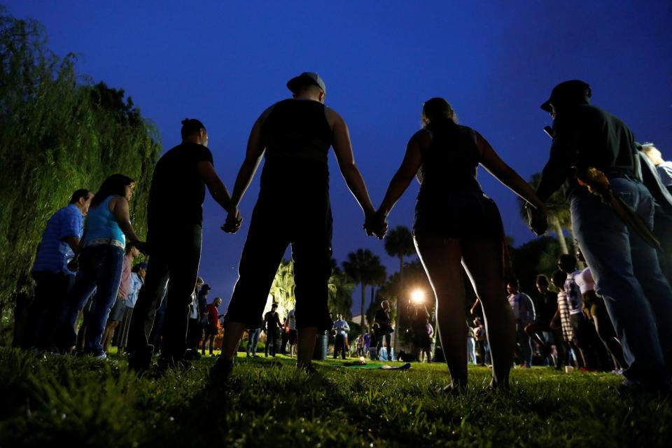 <p>People hold hands in a circle during a vigil in a park in Orlando, Fla., June 12, 2016. (Carlo Allegri/Reuters) </p>