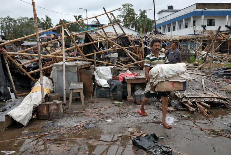 A man salvages his belongings from the rubble of a damaged shop after Cyclone Amphan made its landfall, in South 24 Parganas district