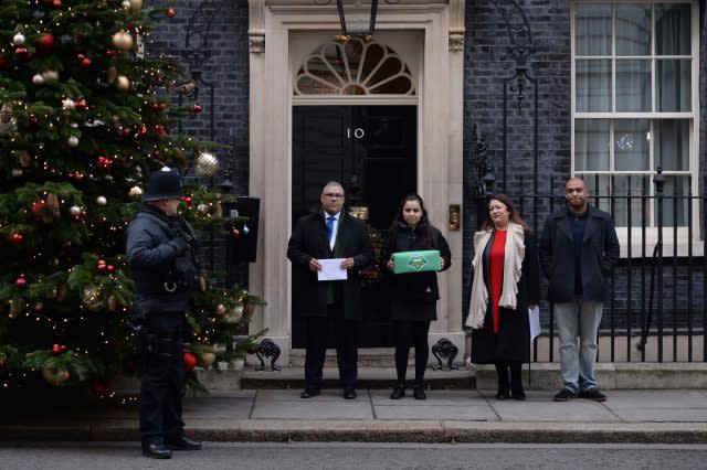 Nicholas Burton (left), Sandra Ruiz (second right), Karim Mussilhy (right) and a girl who asked not be named (second left), hand in a petition to Downing Street (Stefan Rousseau/PA)