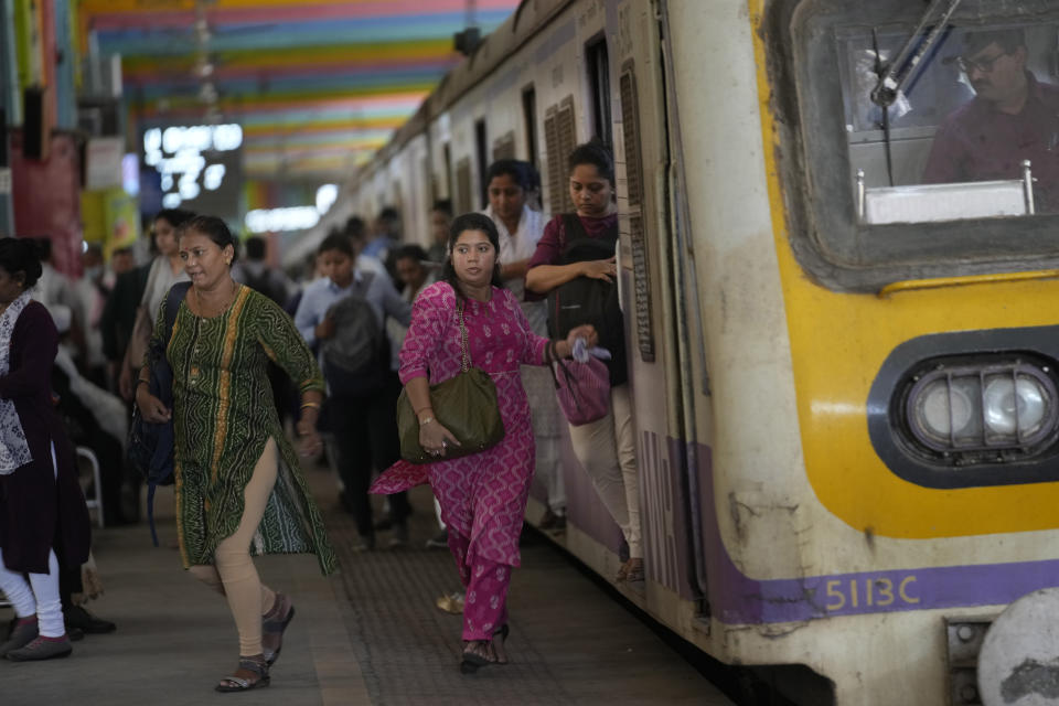 Women rush out of a train during peak hours at Churchgate station in Mumbai, India, Monday, March 20, 2023. 39 million women are employed in India's workforce compared to 361 million men, according to the Center for Monitoring the Indian Economy (CMIE). (AP Photo/Rajanish Kakade)