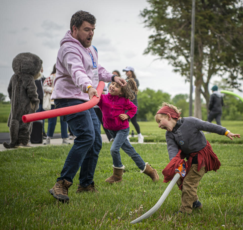 Joshua Gawrick, left, plays with his niece Meredith Folmar, 6, middle, and nephew Joshua Memphis Folmar, 4, during the second annual Josh Fight at Bowling Lake Park, in Lincoln, Neb., Saturday, May 21, 2022. For the second time in Lincoln's history, Joshes from far and wide gathered to defend the right to their name. Non-Joshes also joined the brawl, and together, the crowd contributed to the $20,576 raised for Children's Hospital Medical Center in Omaha. (Jaiden Tripi/Lincoln Journal Star via AP)