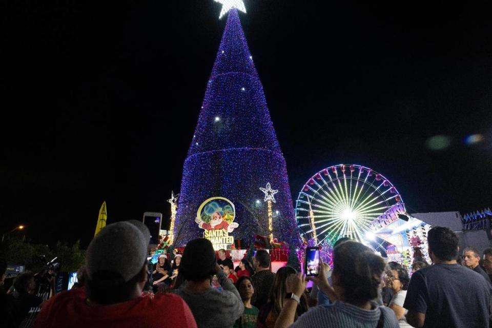 Visitantes toman fotos del encendido del árbol en la noche de apertura de Santa's Enchanted Forest. Alie Skowronski askowronski@miamiherald.com
